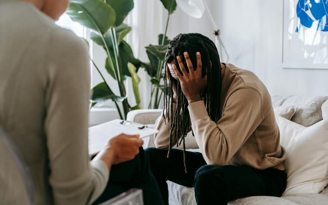 Stressed black man with dreadlocks in psychological office